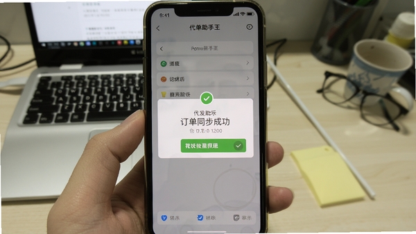 代发助手王的手机端运行截图，显示订单同步成功提示，背景为浅黄色，模拟真实使用场景，界面清晰