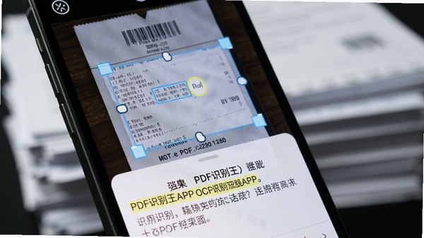 PDF识别王APP的OCR识别功能特写，手机屏幕显示一张票据照片，识别框框住文字区域，下方弹出识别结果文本，文字高亮显示，背景有模糊的文档堆叠，画面细节丰富，突显技术感与实用性