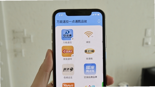 生成一张手机屏幕显示万能遥控一点通匹配空调品牌的界面截图，界面清晰列出多个品牌图标，背景为简洁的浅色墙壁，突出选择品牌的便捷性。
