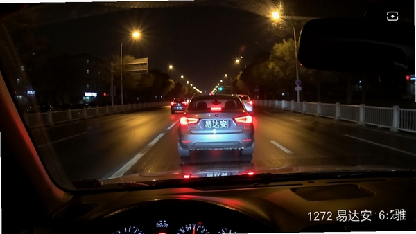 易达安记录仪夜间行车录像画面，高清画质，清晰显示前方车辆车牌，道路灯光反射，画面真实细腻，体现夜视效果。