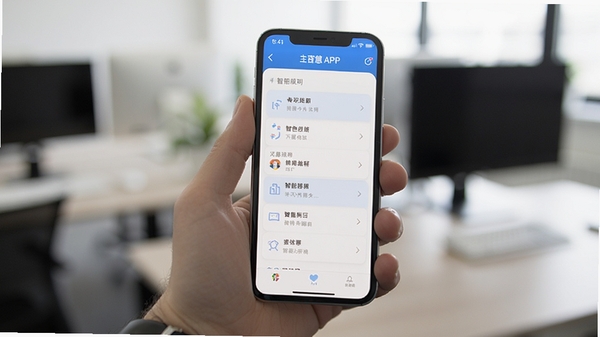 智慧APP在手机上运行的实拍图，手机握在手中，屏幕显示主菜单列表，背景为模糊的办公环境，突出软件在真实场景中的使用状态