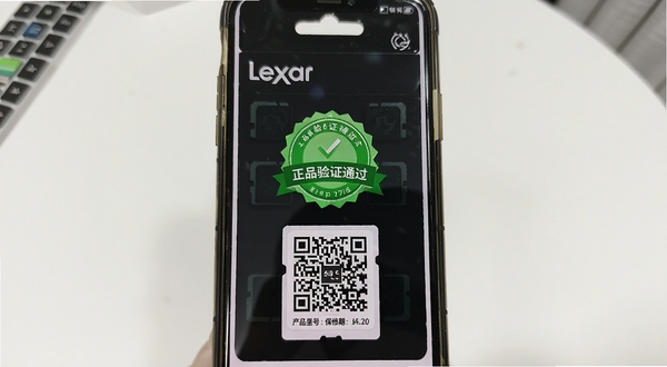 Lexar软件真伪验证页,手机扫描雷克沙存储卡包装上的二维码,屏幕显示“正品验证通过”绿色徽章,并附带产品型号与保修期信息,背景为白色桌面,整体明亮清晰。
