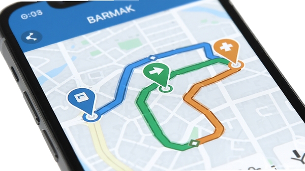 BARMAK导航应用在手机屏幕上显示三条不同颜色的路线规划对比图，画面聚焦于地图上的起点与终点标记，路线分别以蓝、绿、橙展示，背景为简洁的浅色城市道路网格，突出智能规划功能，画面明亮清晰，无文字水印。