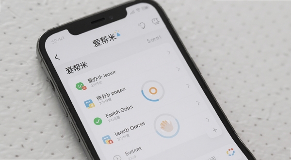 爱帮米智能提醒功能预览,手机屏幕显示待办列表和提醒时间设置界面,背景为浅灰色,应用名称“爱帮米”在屏幕上方,整体风格清爽,注重细节展示