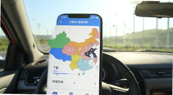 卫星百斗智能导航APP的离线地图下载界面,手机屏幕上显示中国地图分区色块,并有下载进度条与存储空间提示,背景为户外自驾车窗视角,阳光明媚,强调离线可用特点。