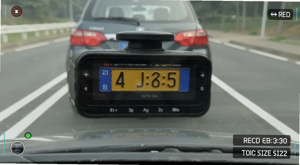 行车记录仪高清录制画面特写，前方车辆车牌清晰可见，道路标线锐利，界面右下角显示录制时长和文件大小，整体色调自然，模拟手机屏幕截图效果