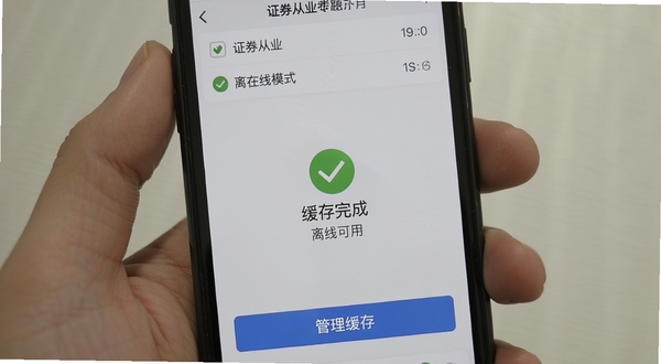 证从业题考拉离线模式提示界面,手机屏幕显示已下载题库列表和离线可用标识,背景为浅灰色,页面中央有对勾图标表示缓存完成,底部有管理缓存按钮,整体风格简约实用