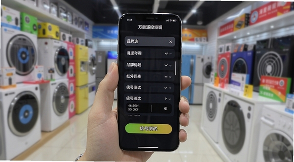 万能遥控空调通连红外码库匹配界面，手机屏幕展示着品牌选择列表和信号测试按钮，背景是模糊的家电卖场环境，色彩丰富，突出海量码库的视觉概念