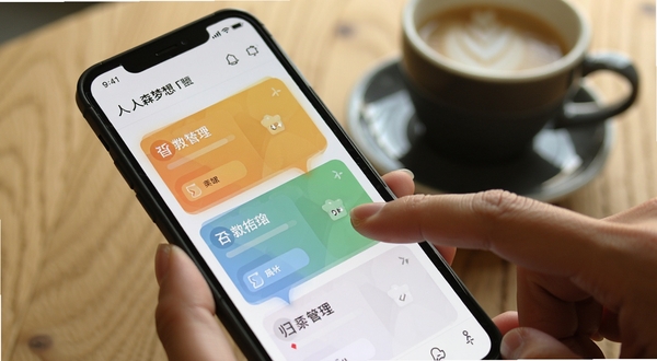 人森梦想 任务管理界面特写 画面主体为手机屏幕显示彩色任务卡片 手指正在滑动归档 背景为木质桌面与咖啡杯 氛围轻松办公