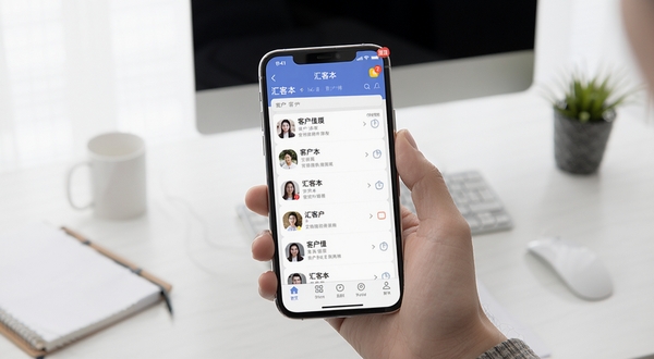 汇客本移动端使用操作示意图，画面主体为手持手机展示应用主界面，背景区域为简约办公桌面，细节包括客户列表、底部导航栏和提醒角标，整体风格贴近真实使用场景