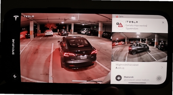 Tesla应用哨兵模式监控画面,手机屏幕显示车辆周围环境录像与警报通知,背景为夜间停车场,画面带有红外夜视效果,突出安全监控功能