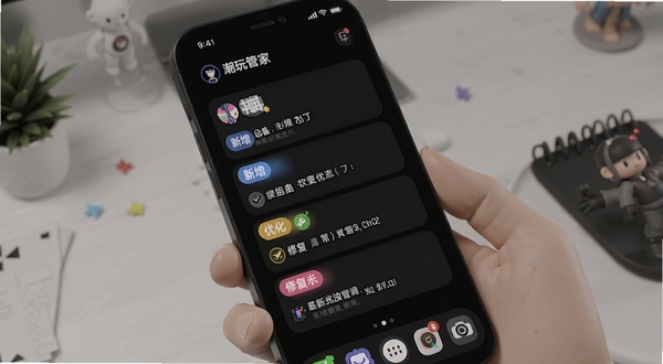 潮玩管家最新版本更新界面展示,手机屏幕显示版本更新日志列表,带有新增、优化、修复的彩色标签,背景为深色模式下的手机桌面,适配Boogu模型生成