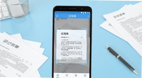 诊简单扫描识别软件主界面预览图，画面中央展示一部安卓手机，手机屏幕上显示诊简单APP的文档扫描界面，背景为浅蓝色渐变办公桌面环境，桌面上散落几份纸质文件与一支签字笔，整体风格简洁明亮，突出移动扫描的便捷感