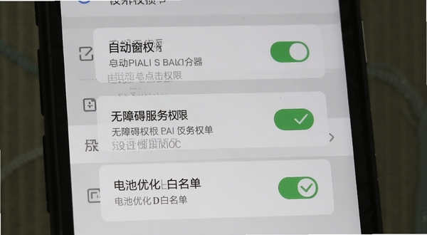 自动点击连点器移动端安装权限设置示意图,画面展示手机屏幕上依次排列的悬浮窗权限、无障碍服务权限、电池优化白名单三个设置项开关,每个开关旁边有绿色对勾标记,背景为浅灰色系统设置界面风格。