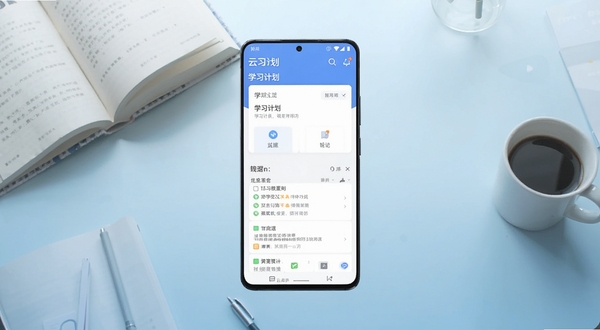 云习应用主界面全貌展示，画面主体为一部竖屏安卓手机，屏幕中央显示云习软件首页，包含学习计划卡片与笔记列表，背景区域为浅蓝色渐变书桌场景，桌上散落书本与咖啡杯，整体风格清新简约，适配Boogu模型生成