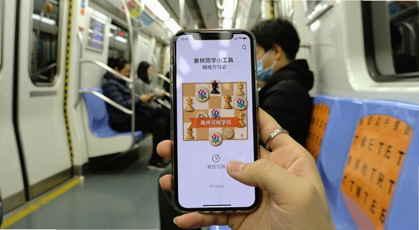 一部手机在无网络环境下打开象棋简学小工具,屏幕显示离线可用提示,背景是地铁车厢或户外长椅,画面明亮简洁,突出随时随地学习象棋的便捷性