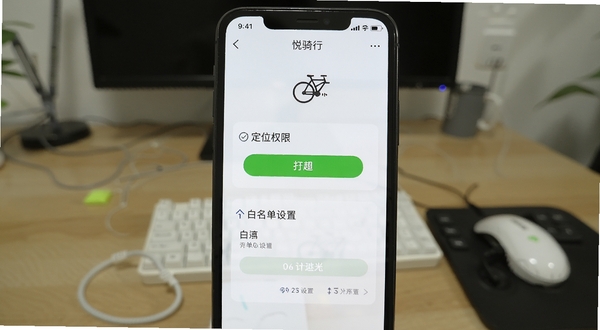 悦骑行软件上手设置界面截图,展示定位权限开启和白名单设置步骤,手机屏幕清晰,背景为室内桌面,风格简洁
