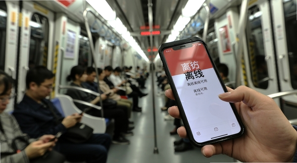 器出东方弱网环境使用场景图,画面为地铁车厢内乘客手持手机使用应用,屏幕显示离线可用提示,背景为车厢内部环境,光线柔和