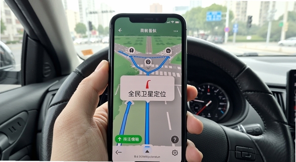 全民卫星定位导航 城市道路交叉口 手机界面显示三条备选路线 偏航提醒弹窗 驾驶视角 日间光线