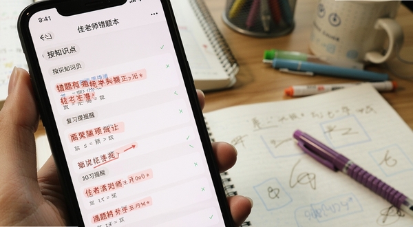 A佳老师错题本功能界面特写，手机屏幕显示按知识点分类的错题列表，带有红色标记和复习提醒，背景是书桌和文具，营造专注学习氛围