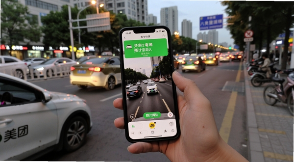 用户手持手机在街边使用美团打车叫车,屏幕显示车辆接单与预计到达时间,背景为傍晚城市街道与车流,画面真实自然,突出移动端使用场景