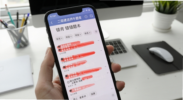 二级建造师牛题库错题本列表页面，手机屏幕展示红色标记错题与筛选标签，背景为简洁办公桌面，突出复习整理场景
