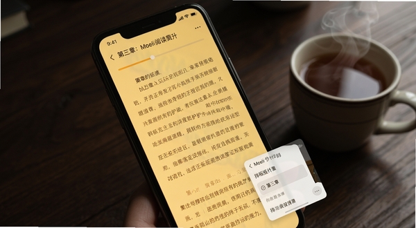 Moeli阅读阅读界面细节展示,画面主体为手机屏幕特写,屏幕内呈现暖黄色护眼背景的小说正文页,字号行距清晰,顶部有章节名与进度条,右下角悬浮排版设置小面板,背景为深色木质书桌与一杯热茶,氛围安静舒适