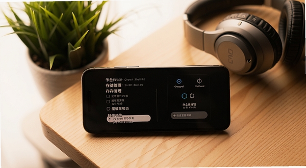 予念应用设置界面展示存储管理与缓存清理选项，手机放置在木质桌面上，背景有绿植和耳机，画面色调温暖，突出轻量省电的产品特点