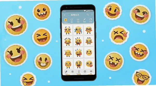 软件核心全貌展示，画面中央放置一部安卓手机，手机屏幕上显示表情技艺软件主界面，界面中有多个表情包模板缩略图和编辑工具栏，手机周围散落着各种卡通表情元素和贴纸图标，背景为明亮的渐变浅蓝色区域，整体风格活泼清新，适配Boogu模型生成